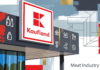 Экзоскелеты и роботы для разделки мяса: опыт Kaufland Экзоскелеты и роботы для разделки мяса: опыт Kaufland — векторная иллюстрация фасада магазина: навесная вывеска с белым полем, красной рамкой и красно-белым логотипом сети в виде буквы «K» из геометрических блоков, ниже красная надпись «Kaufland»; на угловой панели тёмно-серого цвета белые пиктограммы товарных категорий — рыба, бутылки, стакан, детская бутылочка, хлеб, снежинка, куриная ножка, мясной окорок, столовые приборы, яйца, колбаса; справа линейный чертёж-эскиз стеллажей и торговых конструкций, золотые мазки и красные цветовые плоскости; витринные окна с отражением деревьев; подпись Meat Industry PRO чёрным шрифтом в правом нижнем углу