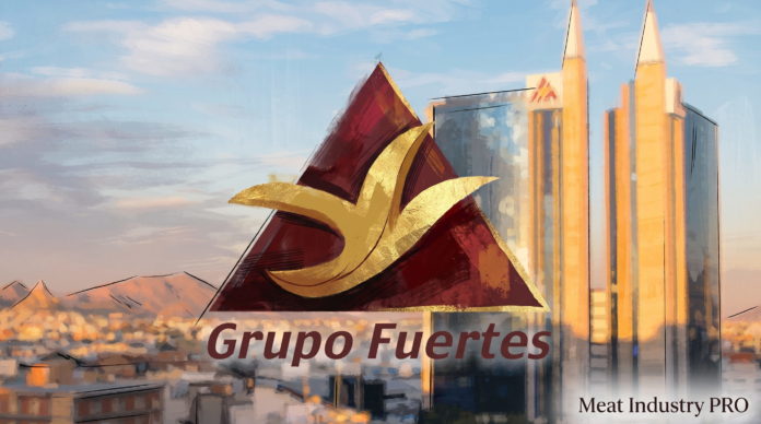 Grupo Fuertes укрепляет птицеводческий бизнес покупкой Nutrave — фантазийная композиция логотипа Grupo Fuertes на фоне промышленного ландшафта в технике цифрового 3D-рендеринга с киноматографическим освещением: крупный абстрактный логотип в центре, состоящий из геометрических форм — треугольник в тёмно-красном цвете с завитой золотистой лентой или полумесяцем, символизирующей движение и динамику; позади логотипа два высоких промышленных силоса или башни в жёлто-оранжевом цвете со стеклянными вставками, отражающими закат; фон — промышленный городской пейзаж с низкими производственными зданиями в коричневых и сером цвете, холмистая пустынная местность в оранжево-красных тонах, голубое небо с розово-сиреневыми облаками, солнечный закат с тёплым светом; внизу слева коричневая надпись 'Grupo Fuertes' в элегантном курсиве, внизу справа чёрная надпись 'Meat Industry PRO'