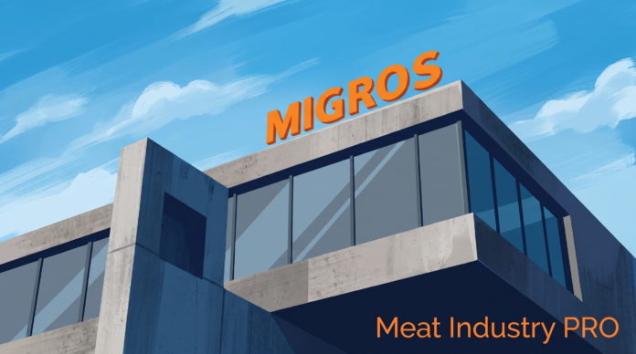 Централизованная вакуумная система Migros для упаковки мяса Централизованная вакуумная система Migros для упаковки мяса — современное здание мясоперерабатывающего предприятия Migros с крупной оранжевой вывеской на крыше, стеклянным фасадом и бетонными конструкциями; иллюстрация выполнена в графичной живописной манере на фоне голубого неба, логотип Meat Industry PRO оранжевым шрифтом в правом нижнем углу